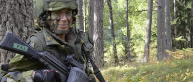 Hemvärnssoldat i stridsutrustning ute i skogen under KFÖ. 