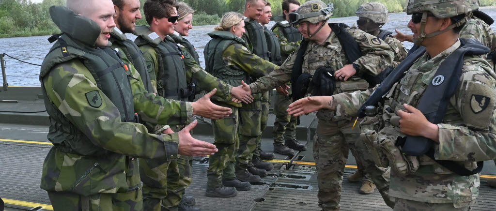 Soldater från olika nationer hälsar på varandra.