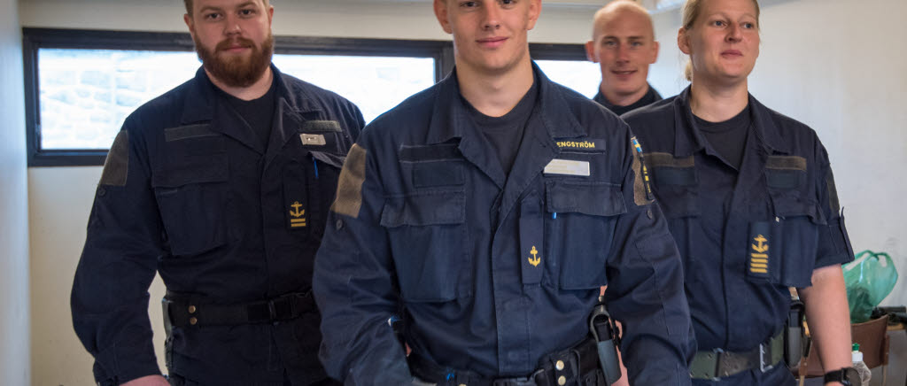 Det är oftast ett leende som möter de som ska passera in till Örlogshamnen. Casper, Carl, Kim och Malin är några av dem som dagligen bemannar vakten i Karlskrona örlogshamn.


Som anställd i Karlskrona garnison inleds dagarna med att man kontrolleras och välkomnas av en leende skyddsvakt vid inpasseringen till Örlogshamnen. Något som oftast ger en väldigt bra start på arbetsdagen. Det är en del av yrket som skyddsvakt i Örlogshamnen. En annan är att ständigt vara beredd att göra utryckningar på skarpa larm, exempelvis. Vid ett sådant tillfälle är det kanske inget leende man möts av. Då är det en väl förberedd, tränad soldat som på en millisekund ska fatta rätt beslut inför den situation han eller hon ställs inför.