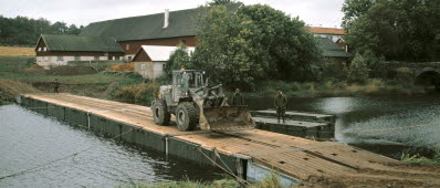 Hjullastare på väg över ponton 100, flytandebro.Strömt vatten