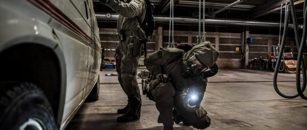 Två CBR EOD-operatörer undersöker en bil som misstänks innehålla både kemiska stridsmedel och hemmagjort sprängmedel.