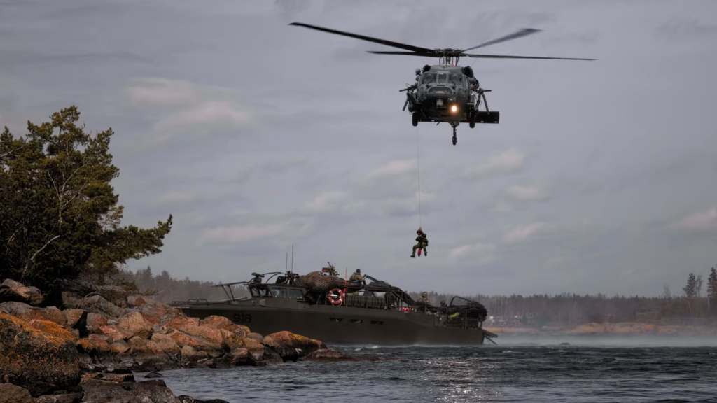 Person firas ner från helikopter till stridsbåt