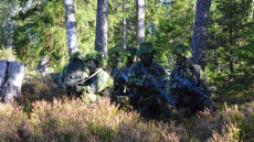 Soldater i igelkottsformering tar emot order från gruppchef.