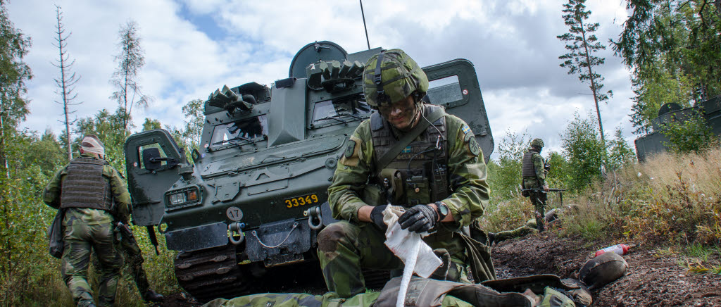 En soldat tar hand om en skadad kamrat efter ett fiktivt eldöverfall.