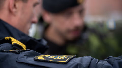 A policeman and a military man in the background