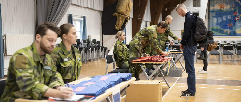 Militärer som sitter vid bord och skriver