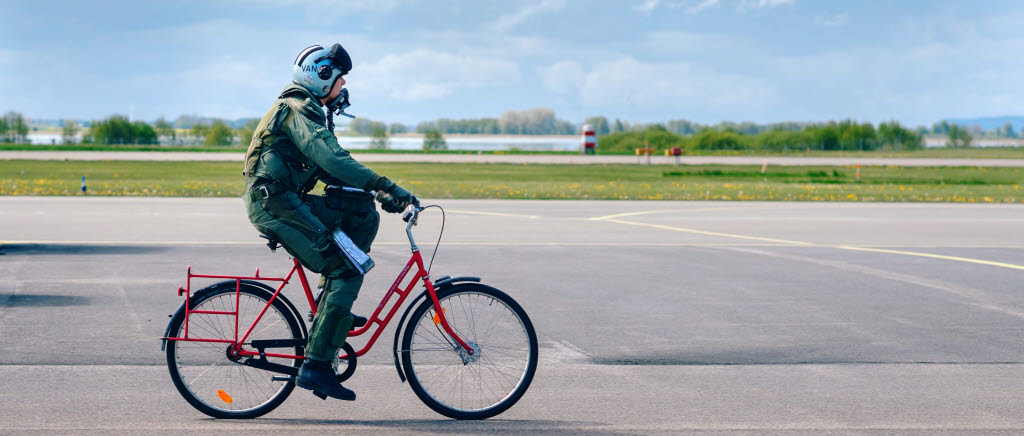 Stridspilot cyklar till sitt flygplan.