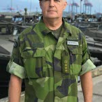 En militär med hamnen i bakgrund.