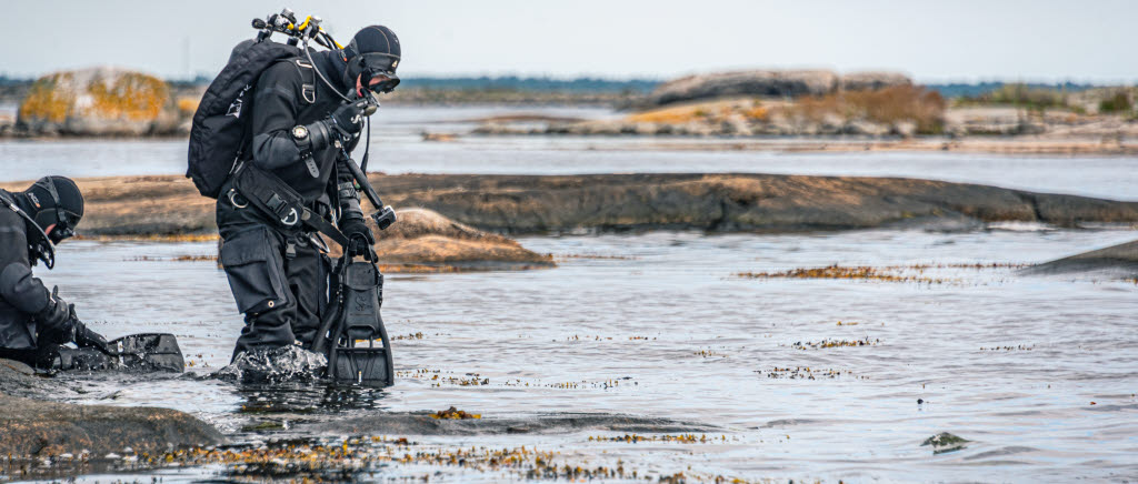 Man kan öva ammunitionsröjning genom att placera ut attrapper av olika varianter som röjdykare får leta efter. Eller kan man som här, under övningen Northern Coasts låta ammunitionsröjare i övningssyfte söka av ett område där det kan finnas skarp oexploderad ammunition att röja. Under två dagar rörde sig röjdykare både på land och i det omgivande vattnet vid Bollö skjutfält. Resultatet blev ett antal skarpa fynd som nu oskadliggjorts.

Internationella röjdykare i RIB-båt Bollö skjutfält

