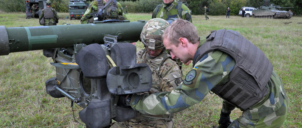 Aurora 17. Robot 70-enheter ur luftvärnet samverkade med en pluton med luftvärnskanonvagnar från P 4 i Skövde och övade mot amerikanska attackhelikoptrar.

Robotskytten Daniel Hansson från luftvärnsbataljonen i Halmstad visar major Romanovski hur robotsystem 70 handhas.