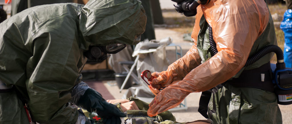 En kombinationsskadad soldat tas om hand under RECCEX 2012. Det betyder att soldaten både är skadad av konventionella vapen och CBRN-vapen vilket innebär att personen både måste saneras och ges första hjälpen.