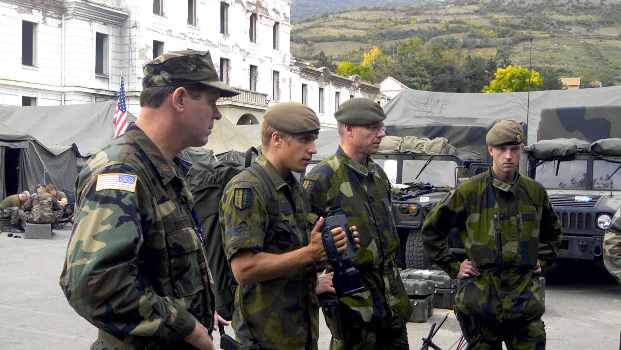 Swedish military soldiers working as a part of the Multinational Brigade South, studies a display of gear used by the Marine Liaison Element (MLE), 24th Marine Expeditionary Unit (MEU) as the Marines of the MLE explain the gear in Prizren, Kosovo during Operation DYNAMIC RESPONSE 2002. 