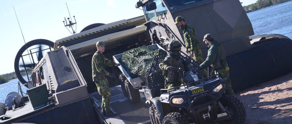 Soldat från 31.bataljon backar ombord ett terrängfordon på svävare från amfibieregementet