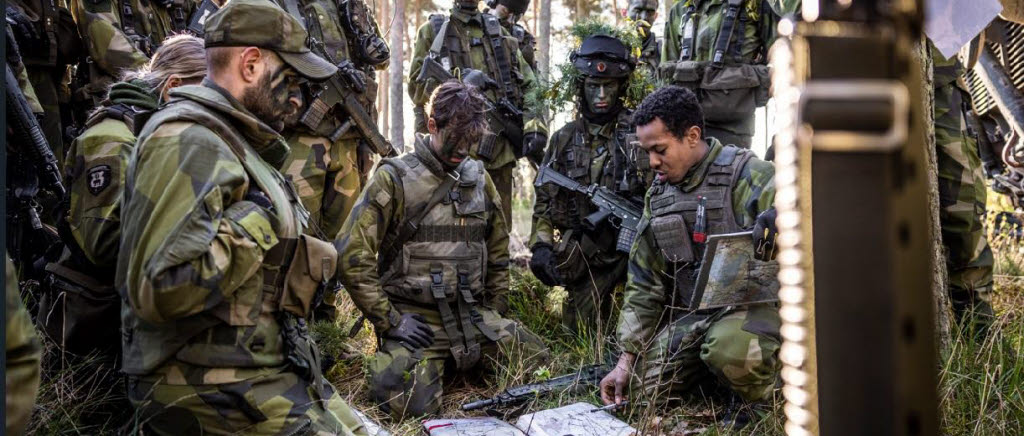 Officerare i fältuniform studerar en karta i skogen
