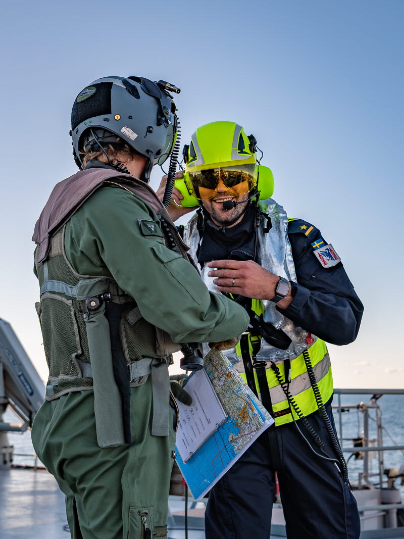 Flight deck officer, FDO är den som leder arbetet på däck och som pratar med flygkoordinatorn på bryggan. Piloterna håller han kontakt med genom tydliga handsignaler. Till sin hjälp har FDO:n en flight deck assistant, FDA som är insatsledare och beredd att arbetsleda säkerhetsarbetet på däck i samband med start och landningar. Skulle något hända leder FDA räddningsinsatserna.

Logistikofficer Melker är en av FDO:erna som utbildats och numer har en ny tillikauppgift.

”Eftersom vi varit samlade på samma plattform har vi kunnat prata med piloterna om vad de tycker är bra eller dåligt i hur vi gör. Det har varit väldigt utvecklande, säger Melker.

Militär flygplats till sjöss. För att säkerställa funktionen har marina fartygsbesättningar drillats under en vecka i september ombord på HMS Carlskrona. Det är Marinbasen som har uppdraget att genom HMS Carlskrona se till att helikopterlandningsförmågan till sjöss inom marinen bibehålls och även taktikutvecklas tillsammans med 3:e helikopterskvadronen.