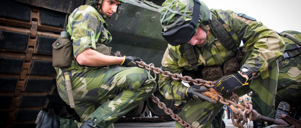 Två soldater ur Tungtranportskompaniet, P 4, säkrar en stridsvagn 122 på dragbilen. 