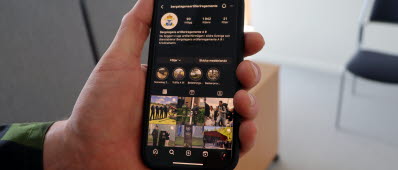 En hand som håller upp en mobil med sociala medier