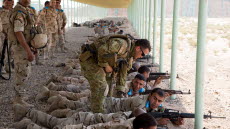 En australiensisk soldat hjälper en irakisk soldat med hans vapen., 29 juli, 2015. 