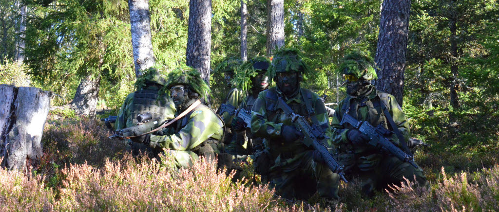 Soldater i igelkottsformering tar emot order från gruppchef.