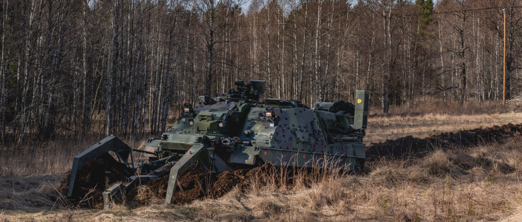 Ingenjörbandvagn 120 använder minplogen för att skapa en väg genom ett minfält.