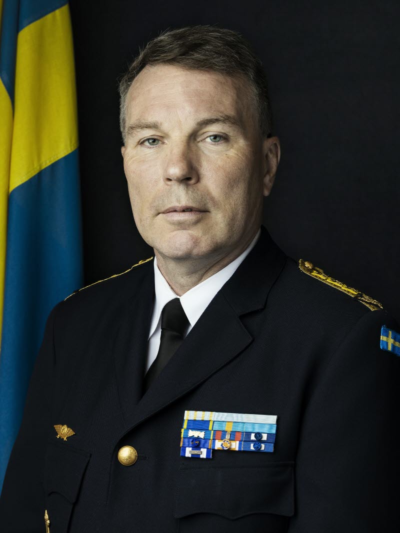 Thomas Nilsson i uniform vid en svensk flagga