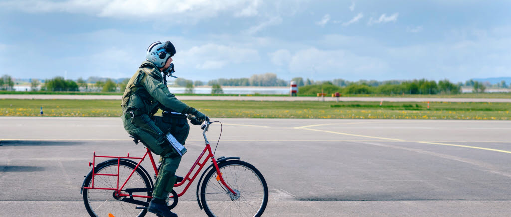 Stridspilot cyklar till sitt flygplan.
