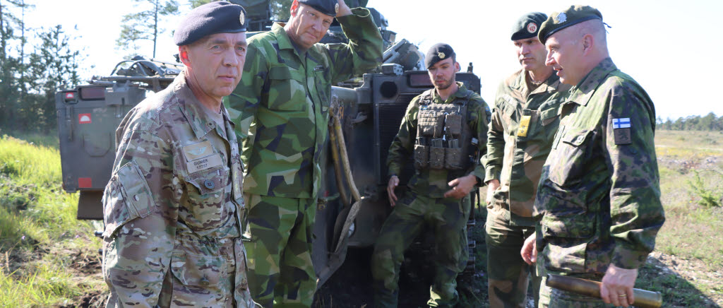 Militärer står vid ett stridsfordon 90. 