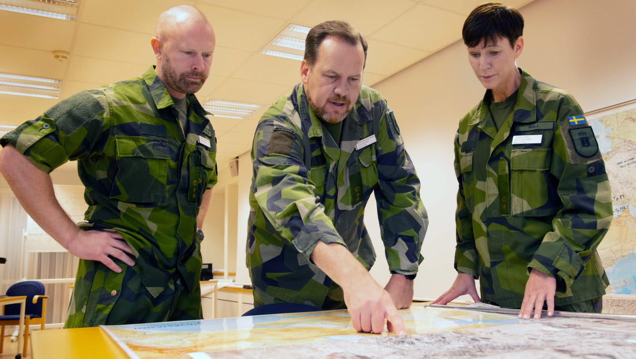 Militärer i rum tittar på en karta.