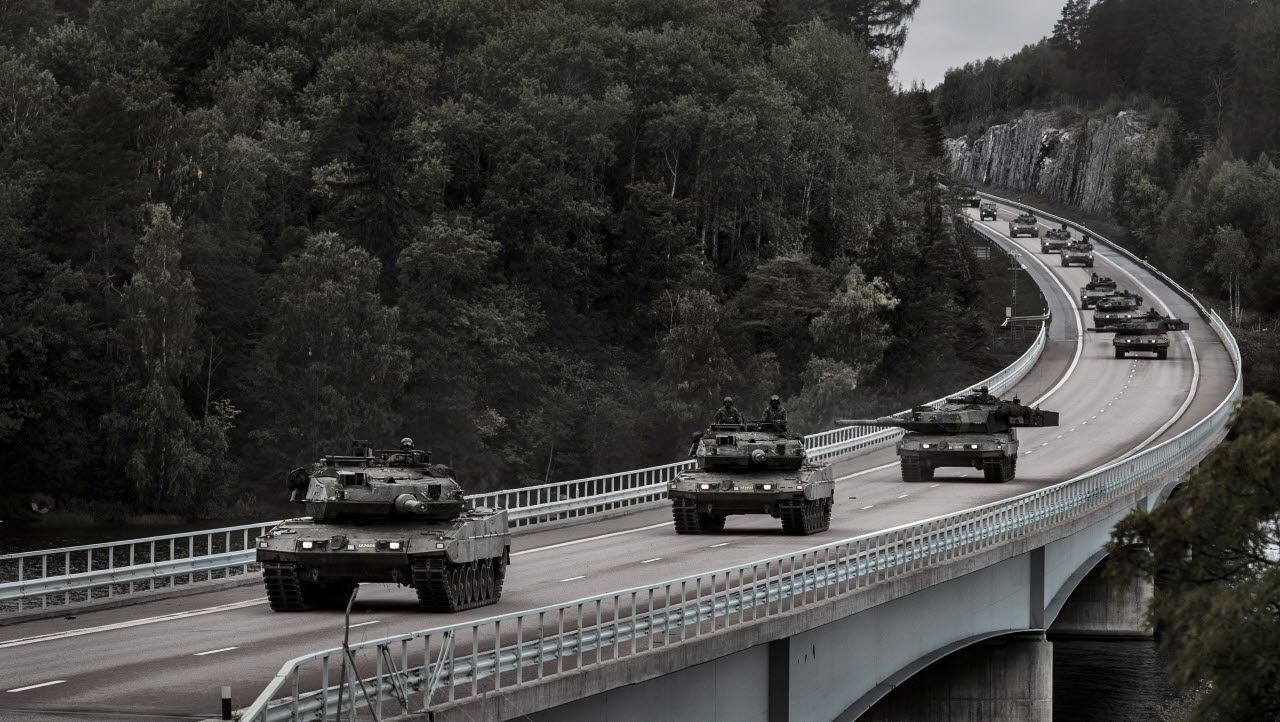 Stridsvagn 122 och stridsfordon framrycker längs med E18.