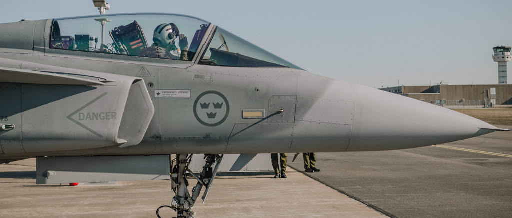 Utländska piloter utbildade på Jas 39 Gripen. Ett nytt flygutbildningskoncept som kallas Försörjningslösning Gripen, FLG.  Det är ett samarbete mellan Försvarsmakten, Försvarets Materielverk samt Flygplanstillverkaren Saab. 
En honnör samtidigt som taxning mot startbanan påbörjas. 