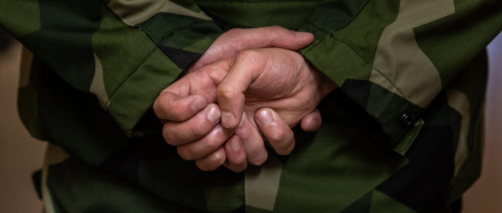 En person håller händerna bakom ryggen. 