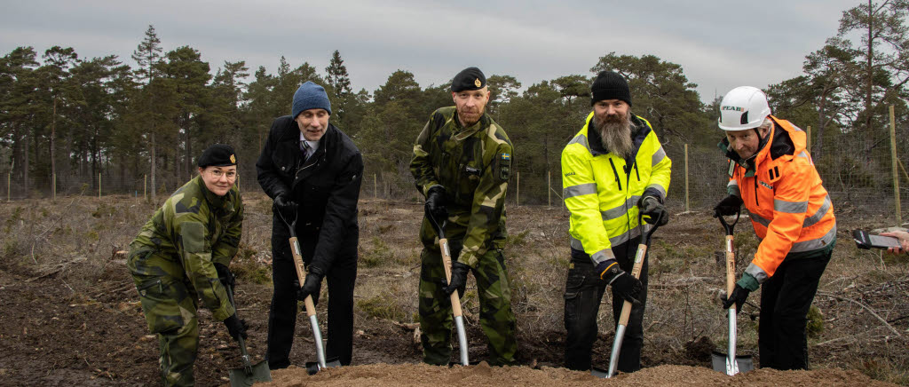 Fem män som gräver med spadar.