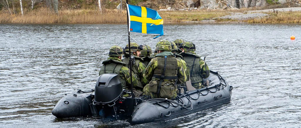 Gummibåt med soldater på vatten.