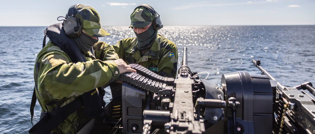 Två soldater ombord på en båt vid en kulspruta
