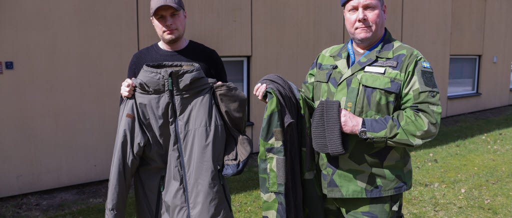 Fredrik Bergman, produktledare vid Försvarets materielverk tillsammans med  Magnus Hallberg visar några av de persedlar som är under anskaffning och under leverans, här syns värmeställ 18, överdragssko, stridsskjorta och trikåmössa.