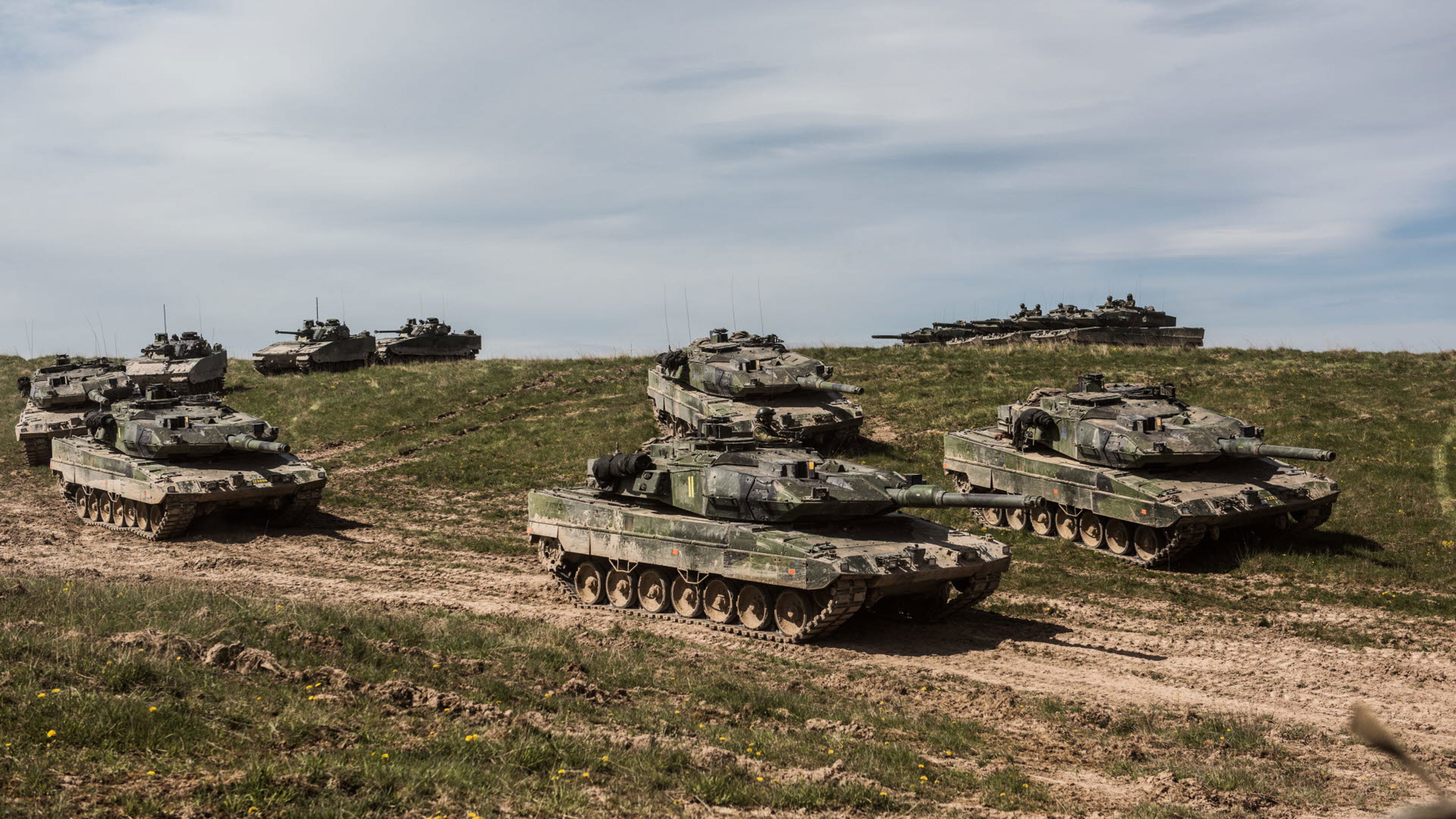 Stridsvagn 122 och stridsfordon 90 på öppet fält.