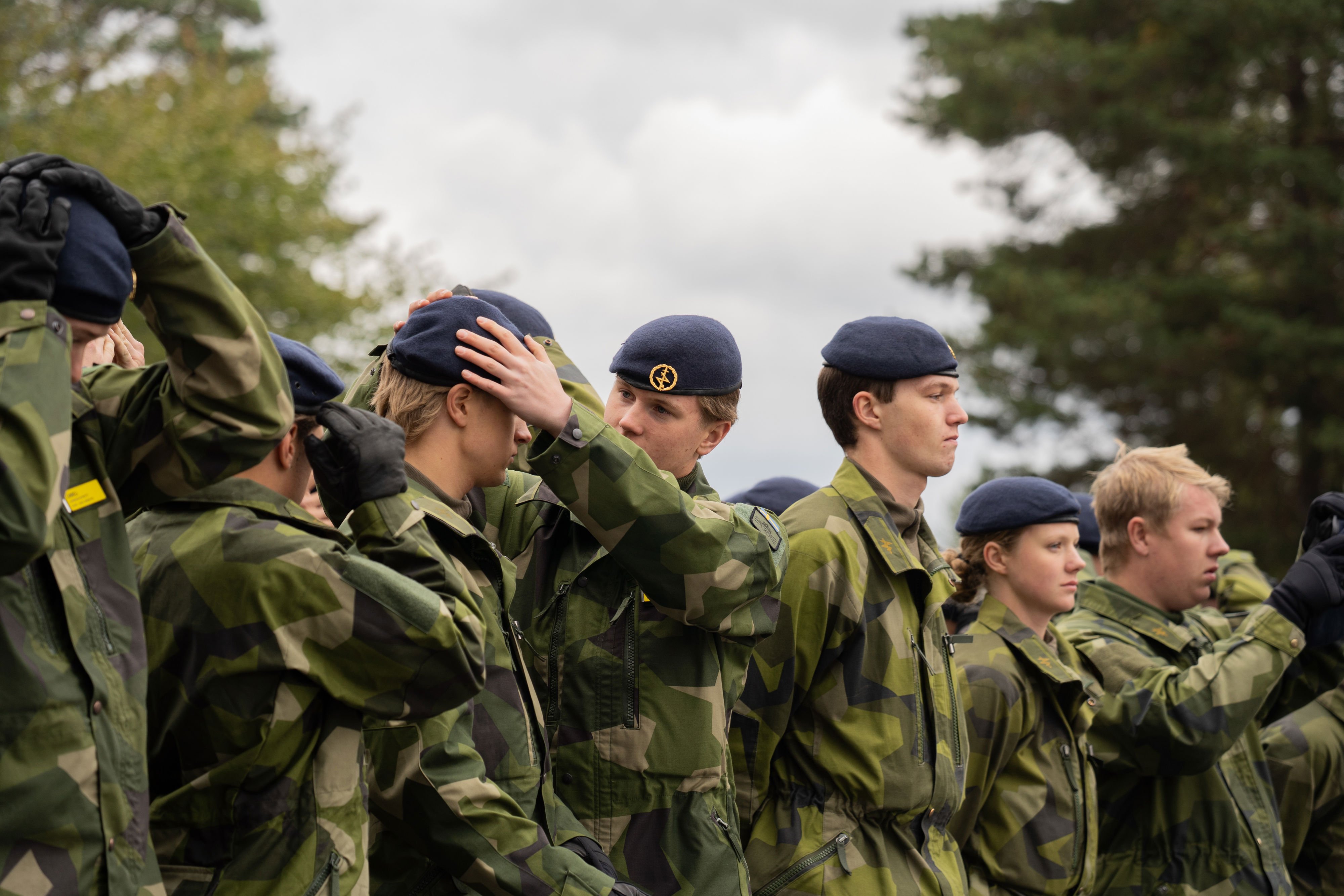 Värnpliktig hjälper kamrat med sin basker.