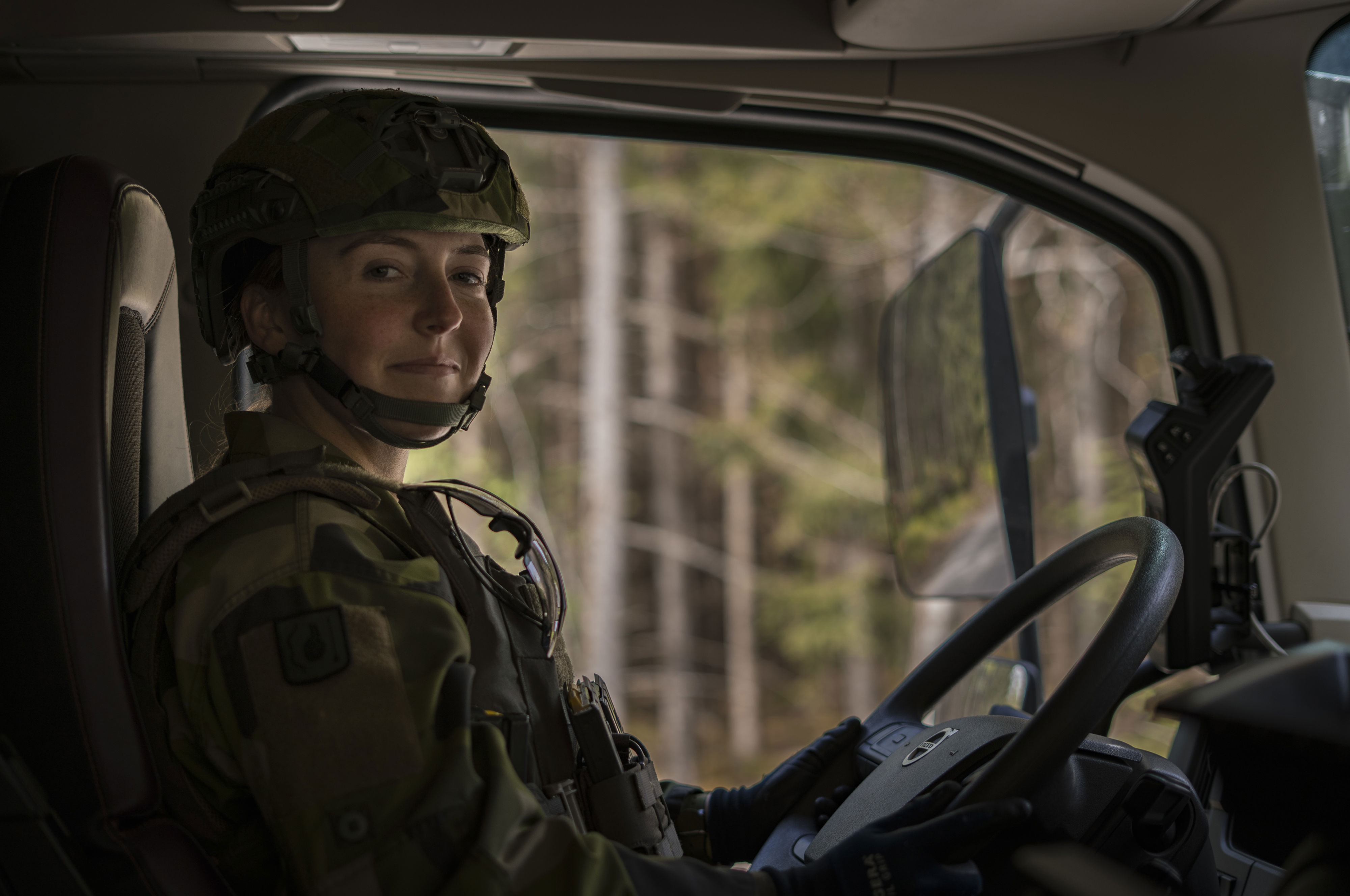 Kvinnlig militär vid ratten på ett stridsfordon.