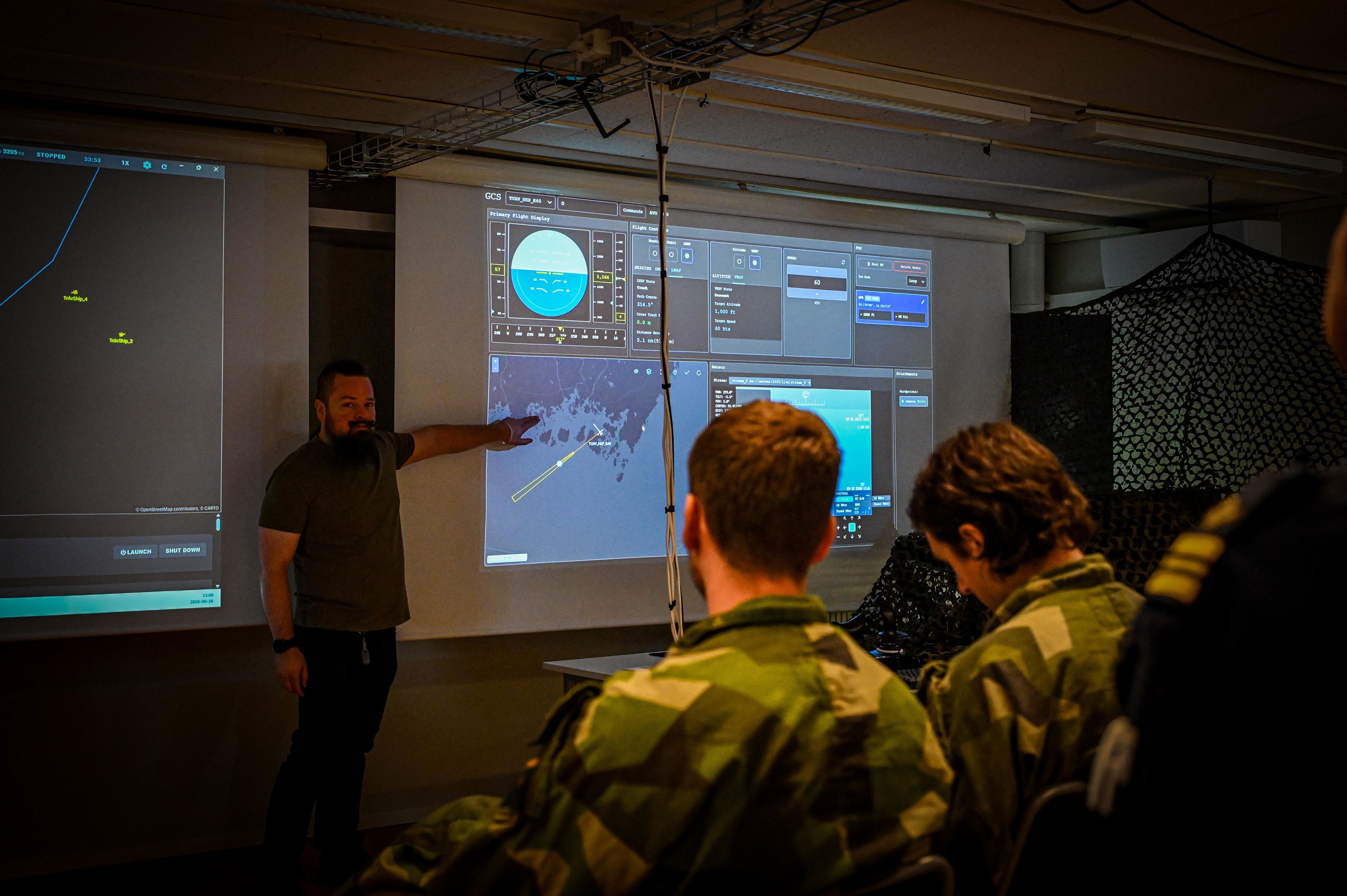Militärklädda män fotograferade bakifrån i klassrum under workshop på luftstridsskolan.