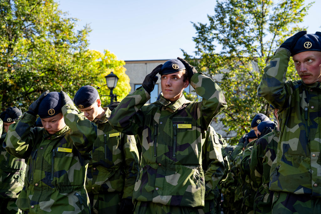 Värnpliktiga sätter på sig sin basker.