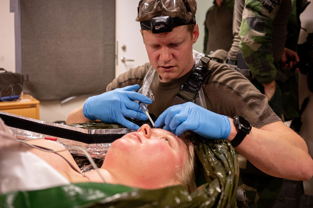 Sjukvårdspersonal vårdar skadad soldat.