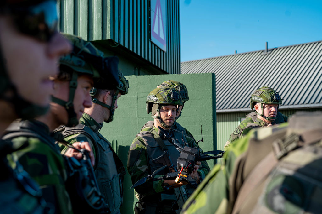 Soldater tittar närmare på en drönare.