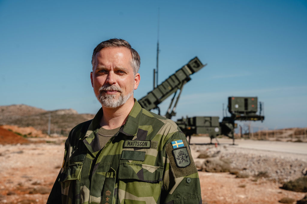 En man i uniform står framför ett militärt luftvärnssystem