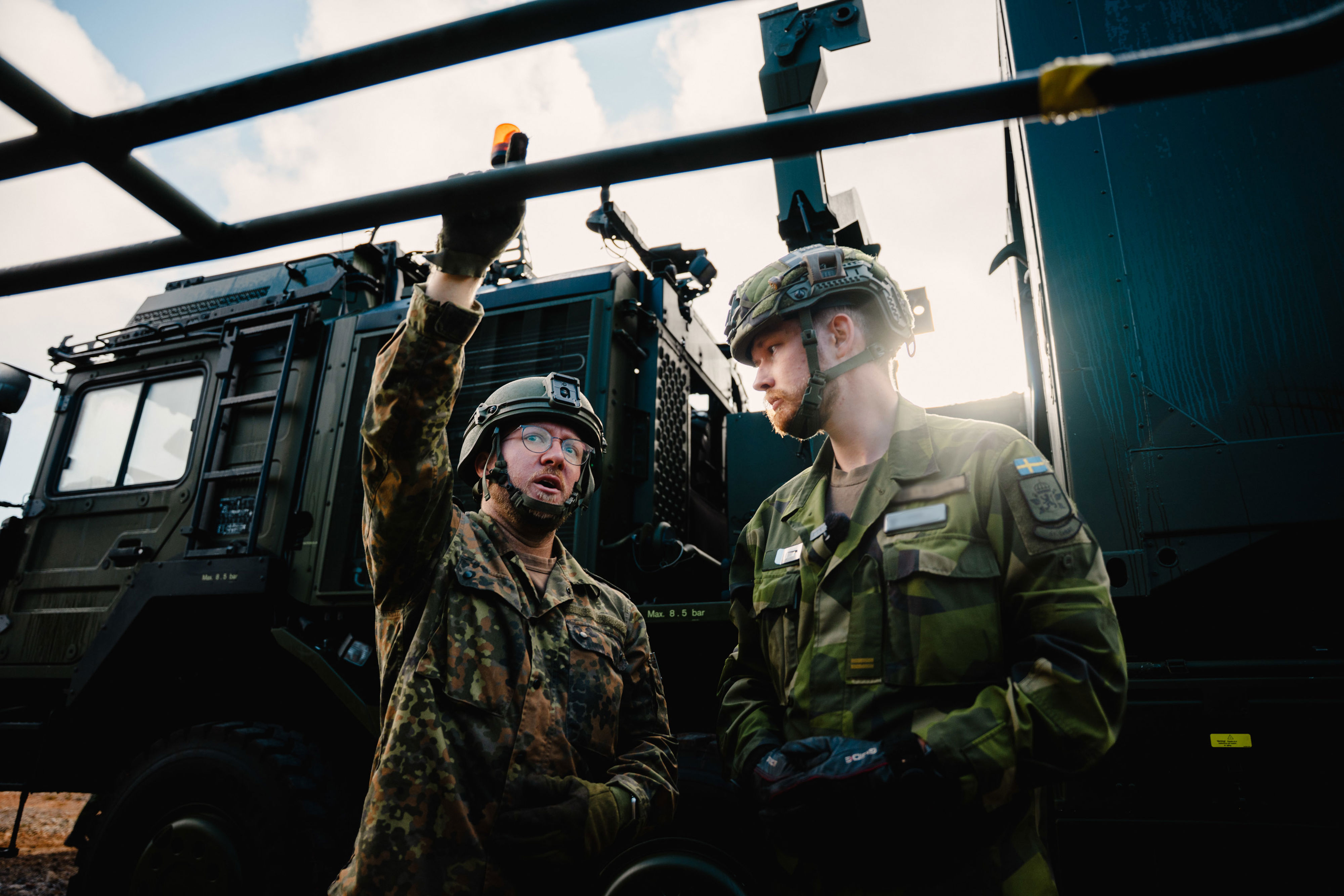 Två soldater står framför ett militärt fordon