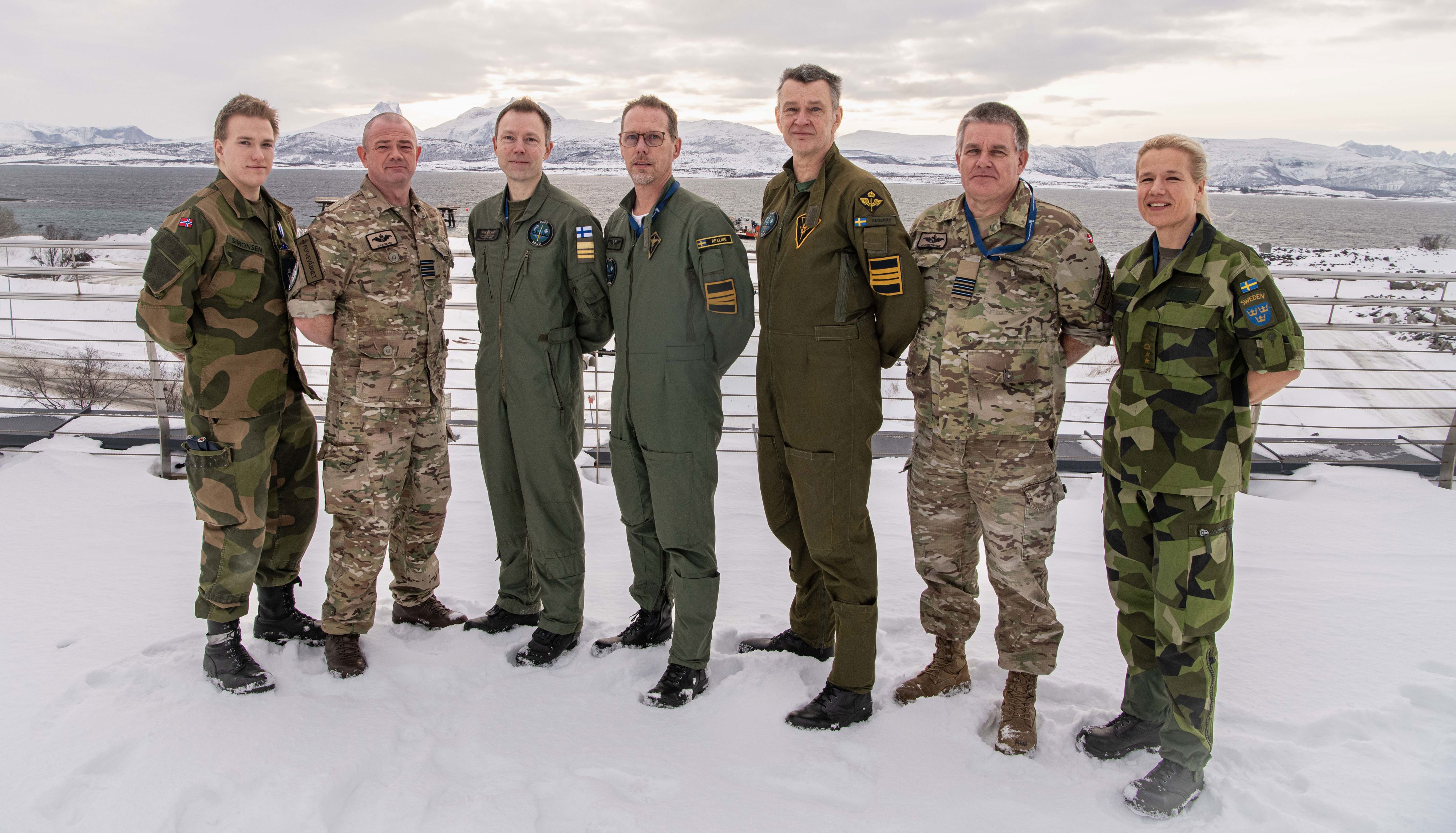 Militär personal uppställda framför ett snötäckt berg i Norge.
