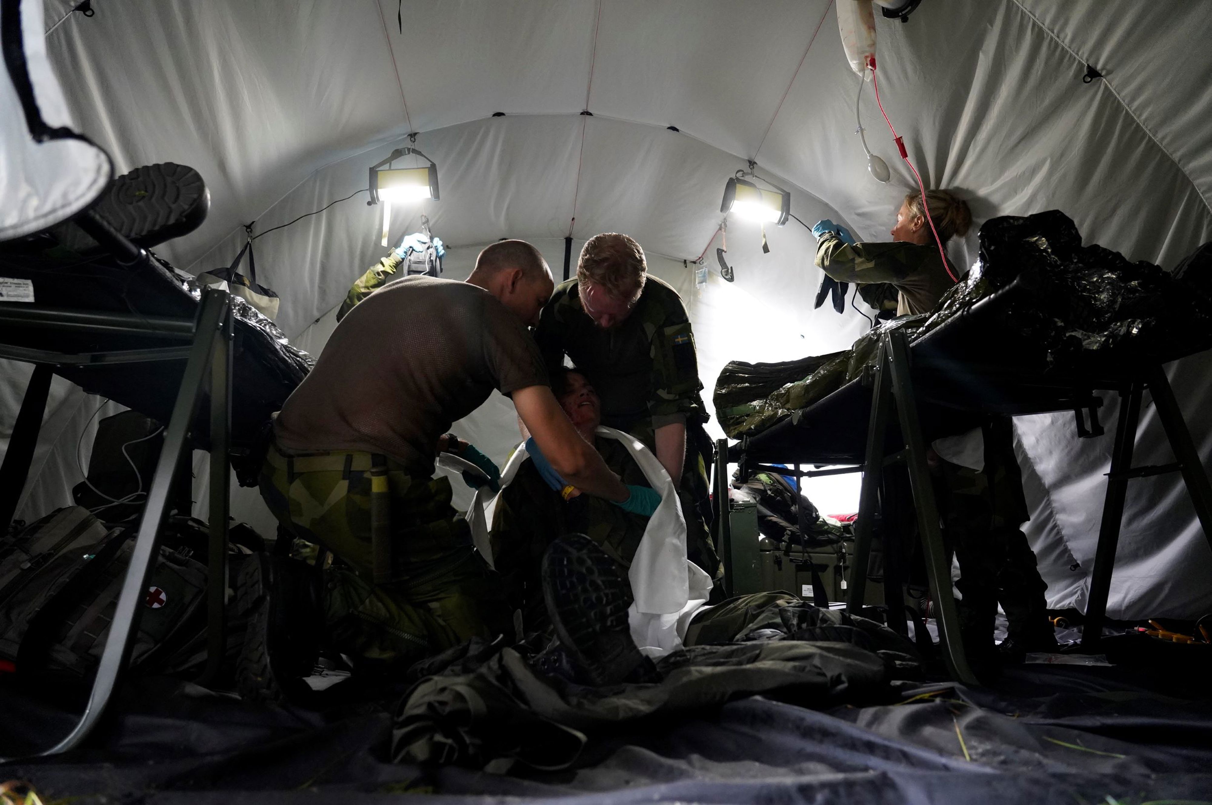Militärsjukvårdare tar hand om skadade patienter i tält