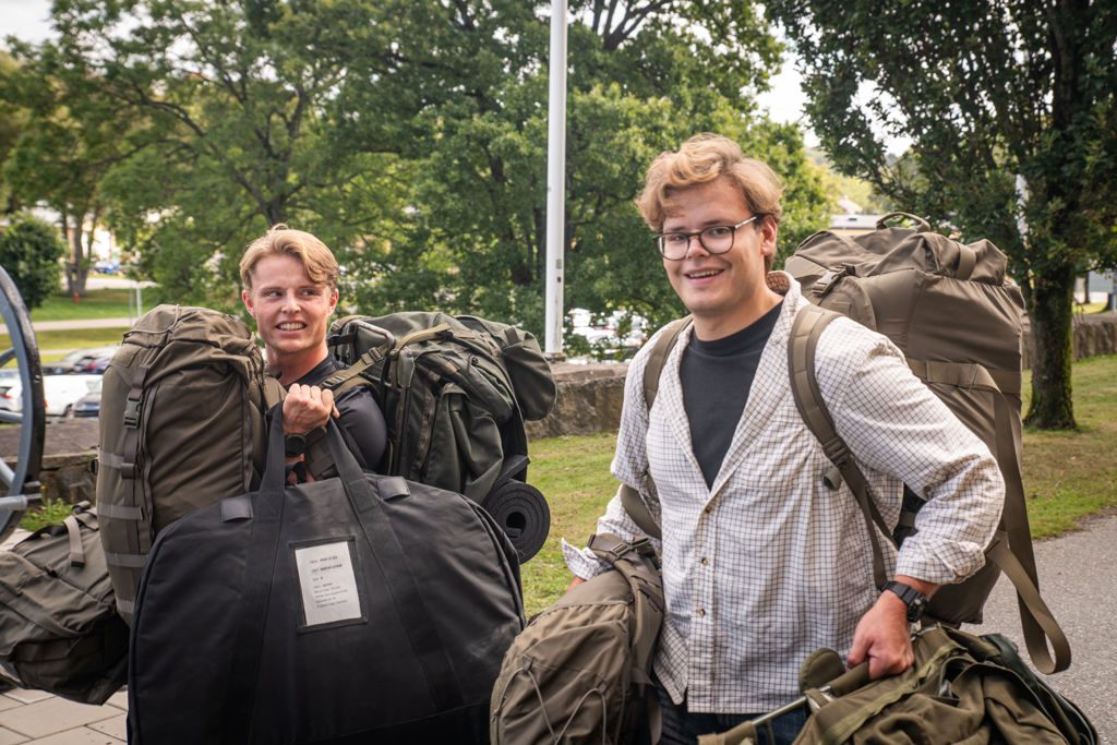 Två civilklädda unga män som bär packning.