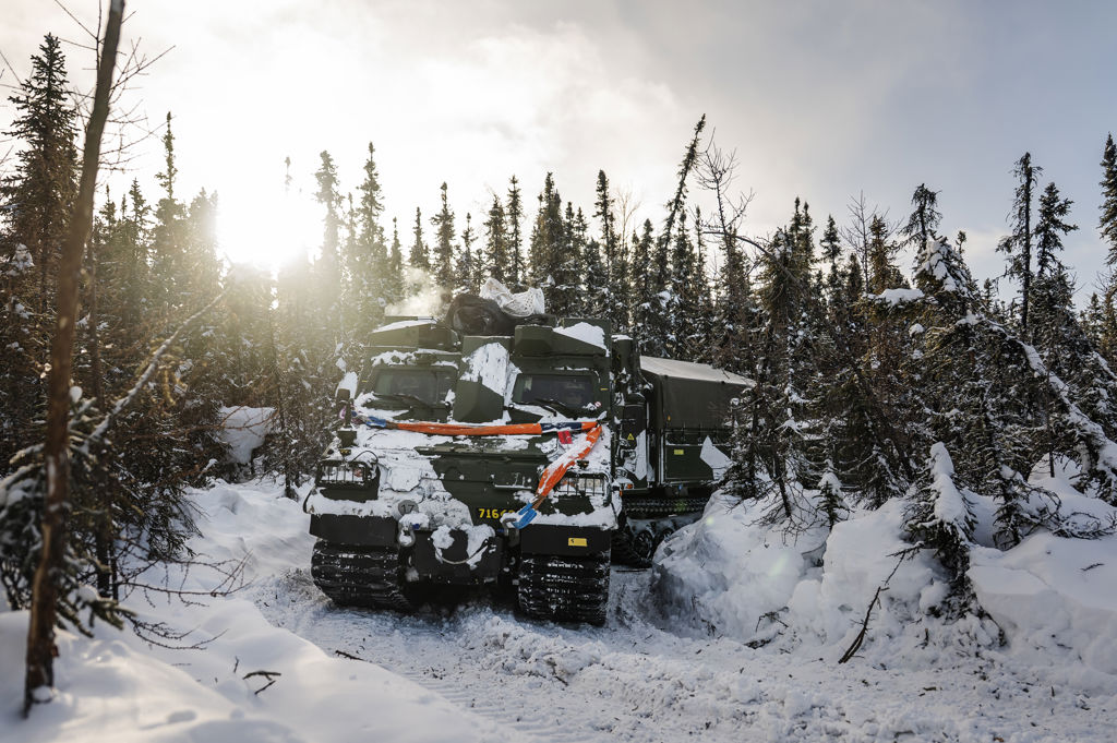 Den svenska bepansrade bandvagnen banar sin väg genom tät barrskog.