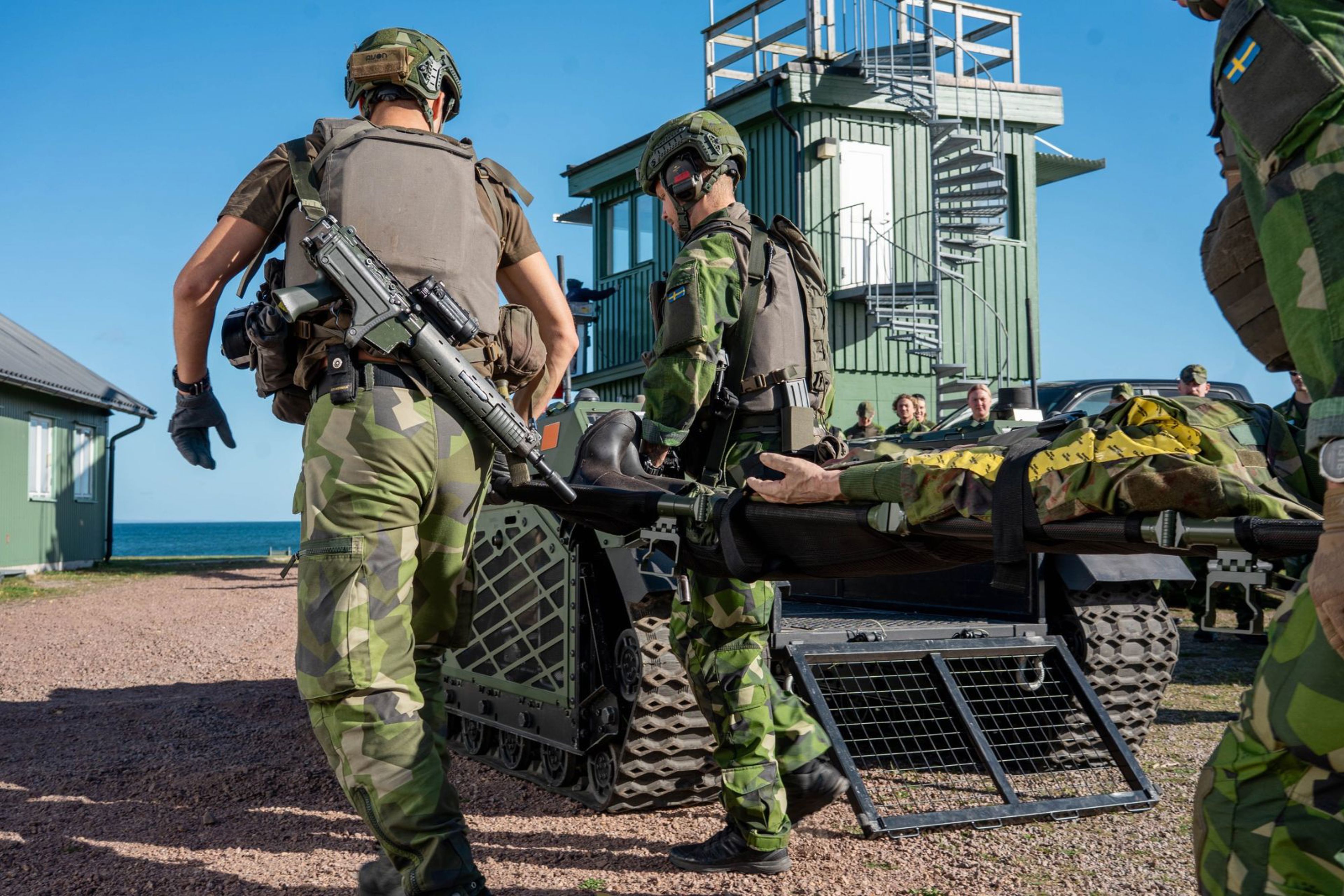 Soldater bär en bår.
