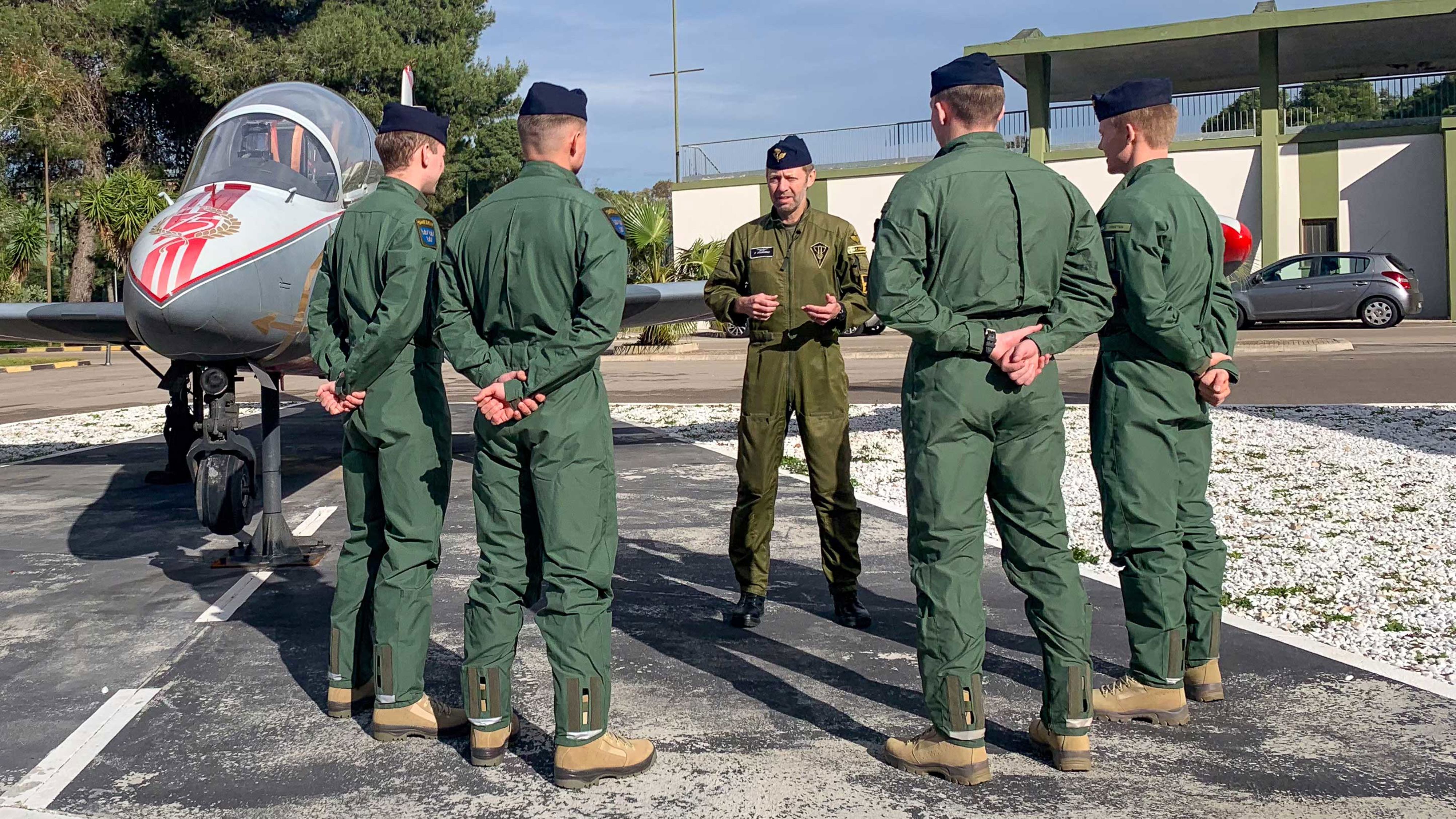 Stridspiloter samlade i en cirkel utomhus.